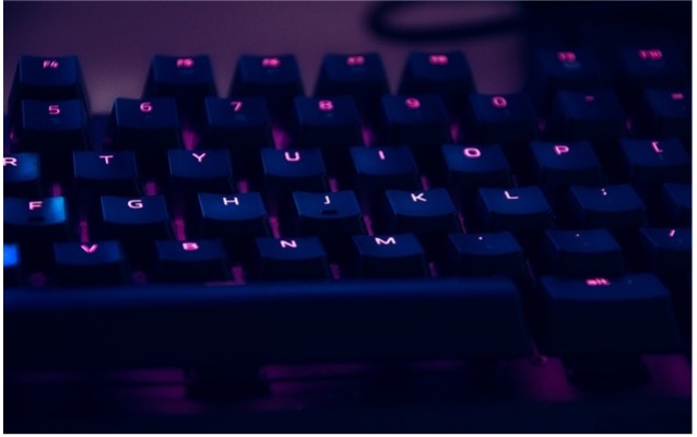 Computer keyboard with pink glow